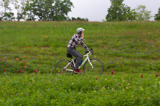 商人骑着自行车接电话-远程工作图片下载