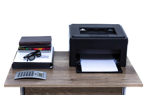 桌上放着激光打印机和办公用品。图片下载
