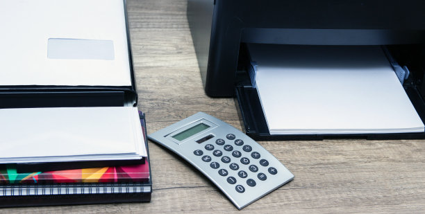 桌上放着激光打印机和办公用品。图片下载