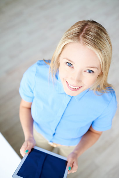 微笑的女人从上面拿着平板电脑图片下载