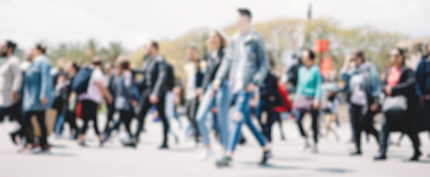 一群不认识的人在散景中走在街上。模糊图像图片下载