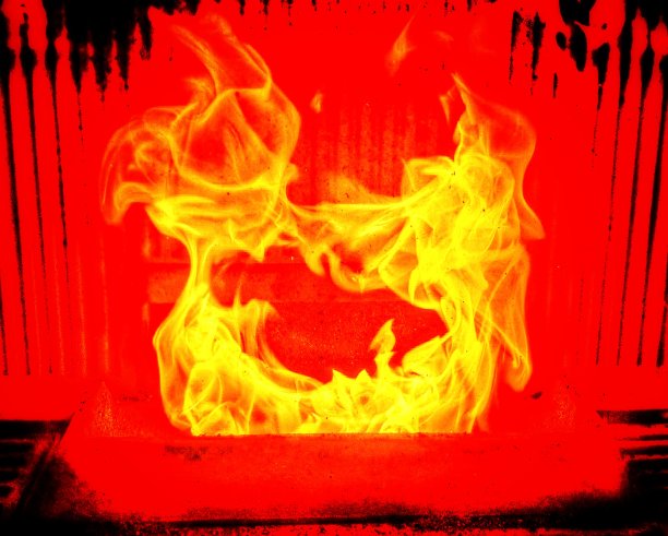 火焰在壁炉中舞动，有着像剪影一样的色彩效果。红色和黑色背景上的亮黄色。图片下载