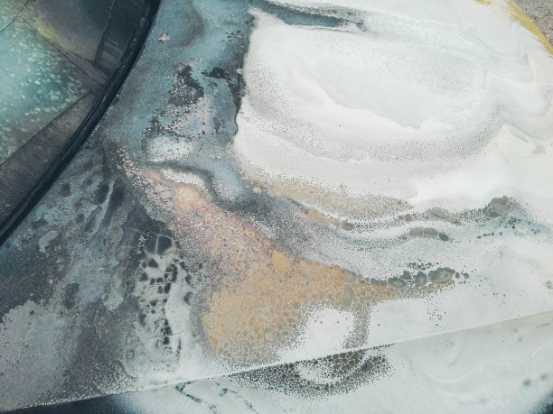 烧毁的汽车的引擎盖。烧毁的汽车停在人行道附近的路上。生锈的烧焦的背景。图片下载