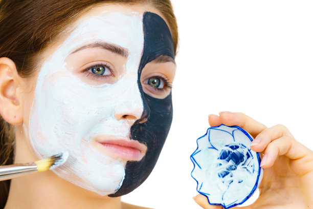 女孩黑色面膜在半脸敷白泥图片下载