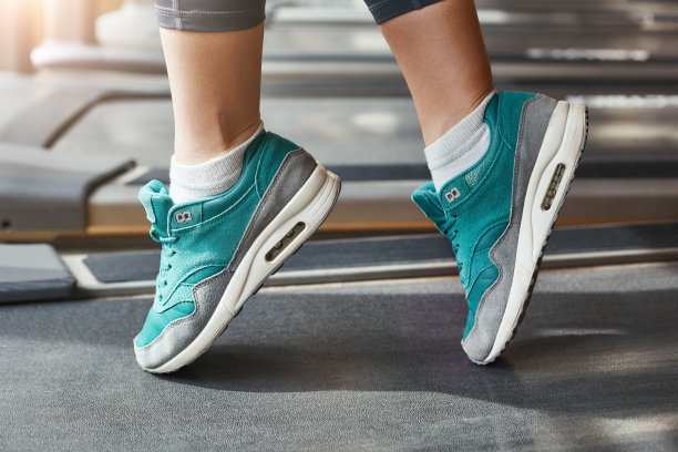 安慰一切。近距离照片的女人脚在蓝色时尚运动鞋站在跑步机上在健身房图片下载