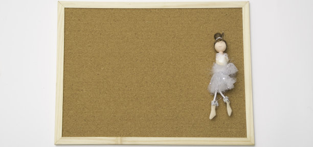 芭蕾舞娃娃在白色空白软木板模拟与软木板纹理背景与木制框架图片下载