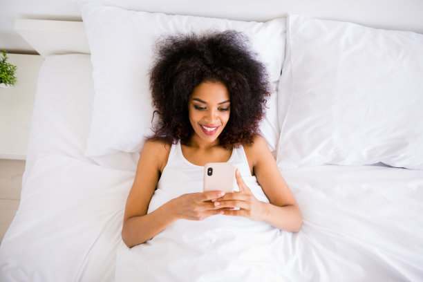 特写，上面，上面，高角度，视图，照片，漂亮的，她，她，她的黑皮肤，女士，周末，假期，双手，手臂，电话，写信，阅读，电子邮件，休息，暂停，白色的睡衣，躺着，躺着，大卧室，房子，室内图片下载