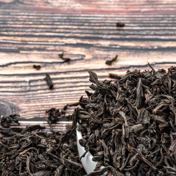 把干茶倒进放在木板桌上的瓷杯里。图片下载