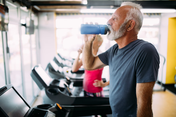 老年人在健身房跑步机上跑步的照片图片下载