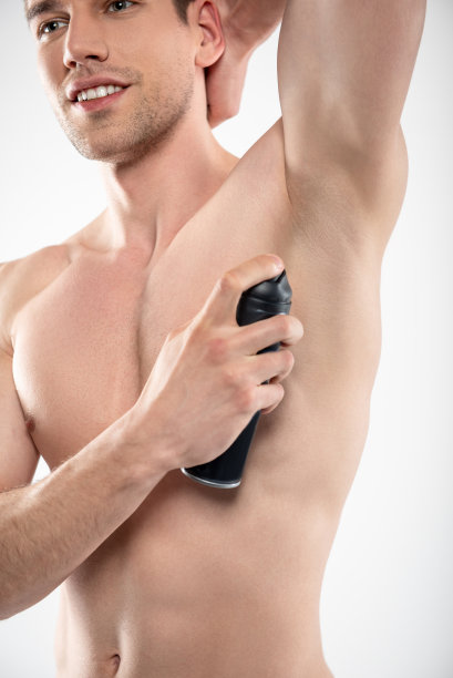 身材完美的帅气年轻人用除臭剂图片下载