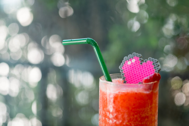 草莓冰沙，红色的彩色果汁，上面有心形玩具装饰图片下载