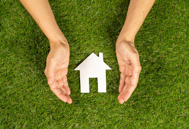 概念性图片妇女手保护白色房子在绿色领域的顶视图和复制空间在房地产投资房地产储蓄和购买住房抵押贷款保险和银行概念。图片下载