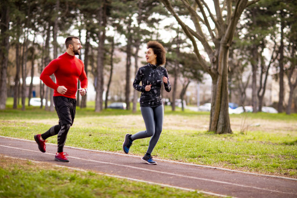 两个运动员在一个公园里并排跑步图片下载