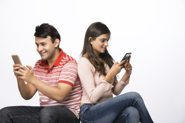 年轻夫妇使用电话-股票图像图片下载