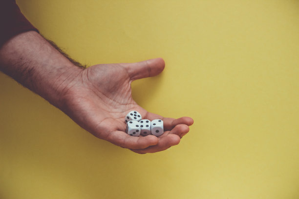 玩骰子在手，孤立在黄色背景。图片下载