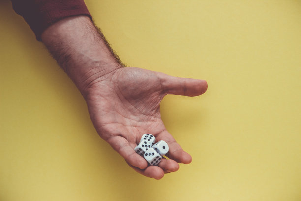 玩骰子在手，孤立在黄色背景。图片下载