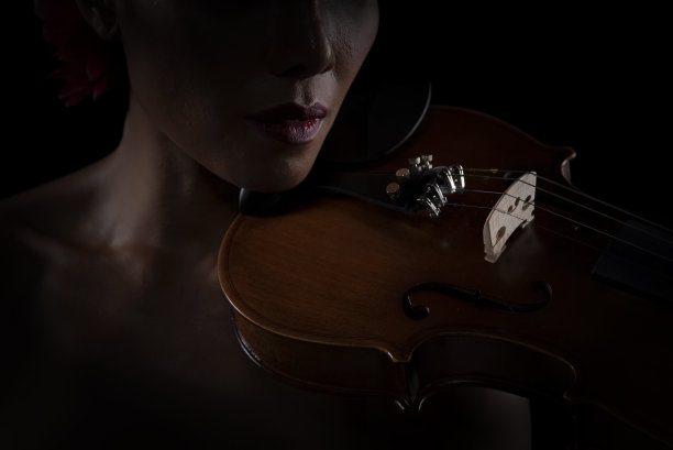 在小提琴正面的选择焦点放在了女人的脸旁边，古典风格，艺术色调，模糊的灯光周围图片下载
