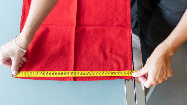 切割和缝纫的艺术。手与卷尺的特写。女裁缝正在测量尺寸图片下载