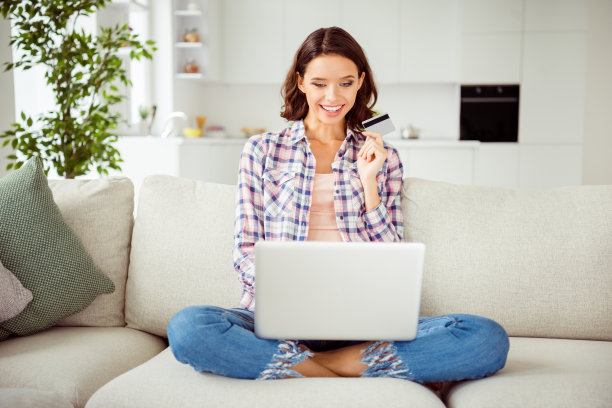 特写照片美丽的她她的夫人鲍勃笔记本塑料无线信用卡手手臂推荐网上购物穿格子衬衫牛仔裤斜纹棉布坐在沙发房子阁楼客厅室内图片下载