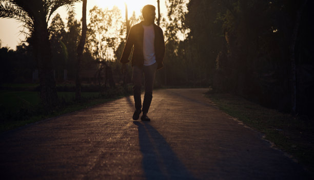一个年轻人在下午走在街上图片下载