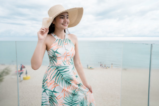 美丽的女人穿着美丽的裙子走在玻璃楼梯暑假。图片下载