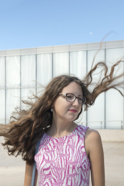 头发在风中飘动的年轻女子图片下载