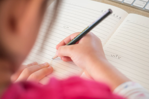 学龄前儿童在纸笔记本上写信图片下载