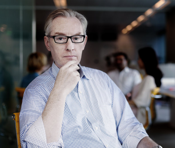 肖像的商人坐在桌子在设计办公室图片下载