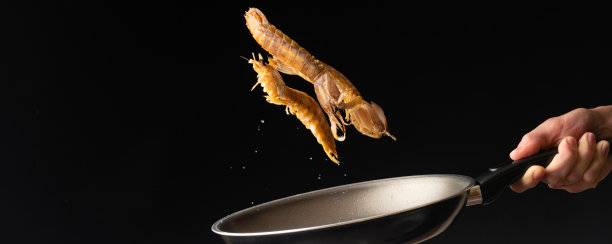 厨师准备海鲜，虾蛄，东亚美食，diilikates，在一个黑色的背景，水平照片，特写，横幅图片下载