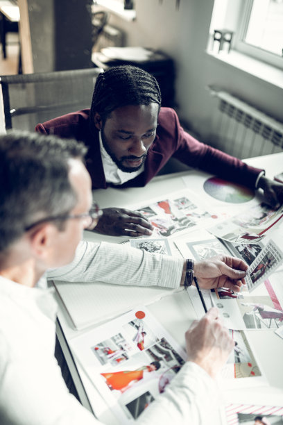 男时装设计师在看模特的照片图片下载