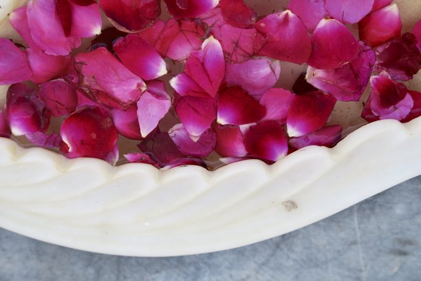 红玫瑰花瓣漂浮在水盘上，传统的印度家庭/酒店/寺庙欢迎客人的照片图片下载