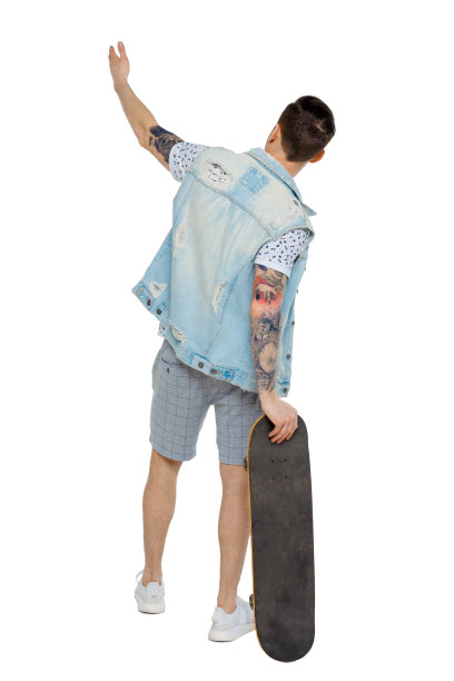 一个拿着滑板的人的后视图。图片下载