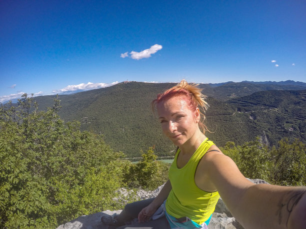 登上山顶后的年轻女子在自拍图片下载