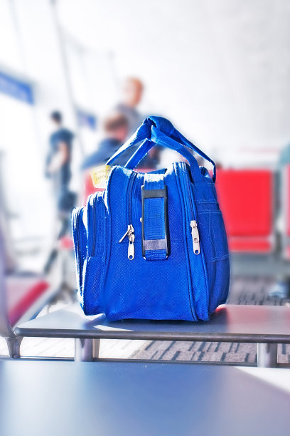 蓝色的手提行李就放在机场的座位上图片下载