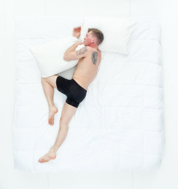 有魅力的男人在床上穿着内衣，上面的观点图片下载