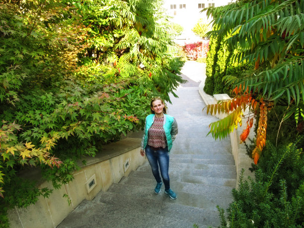 年轻的金发女郎站在乌克兰基辅海达尔阿利耶夫公园的台阶上，看着镜头图片下载