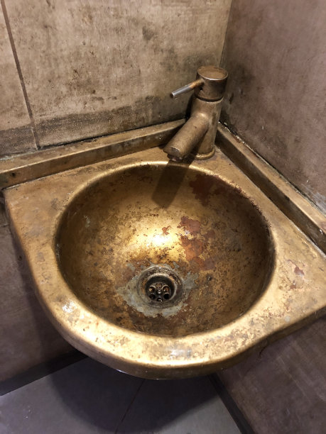 浴室/盥洗室盥洗室的圆形圆形铜角水槽碗，用于洗手和个人卫生，时尚的金属浴室水槽内部设计瓷砖飞溅的背面，老化的铜绿铜绿，水龙头，小角落洗脸盆照片图片下载