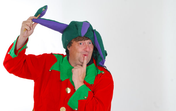 这是一幅中年男子的肖像，他打扮得像个小丑，摆着愚蠢的姿势，表情傻乎乎的，背景是白色的图片下载