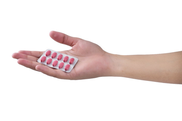 女性手拿一包药丸孤立在白色的背景图片下载