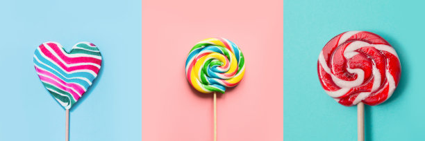 三颗心形的彩色棒棒糖在蓝色和粉色的糖果上打转。拼贴画。图片下载