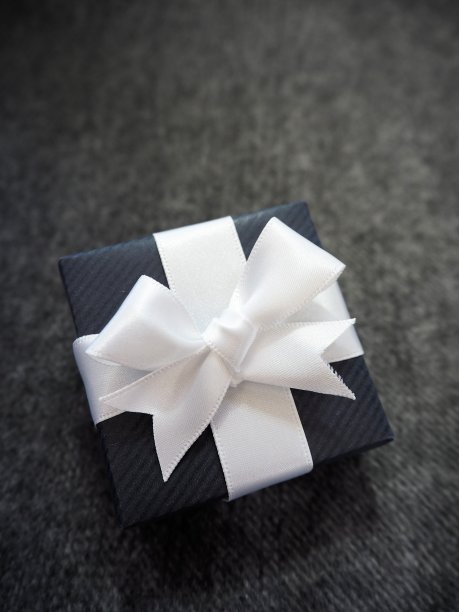 海军礼盒白色丝带在灰色织物背景图片下载
