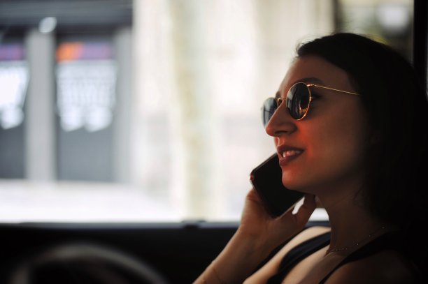 漂亮的黑发女人在出租车里打电话图片下载