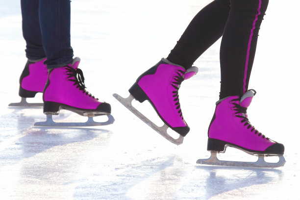 穿着红色溜冰鞋的脚在溜冰场上。爱好和娱乐。体育和假期图片下载