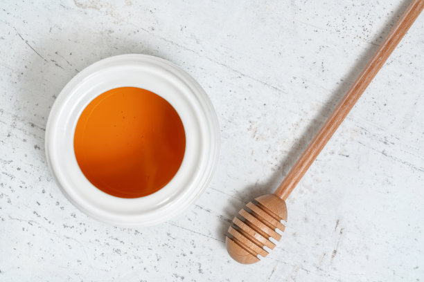 从上往下看，石头桌上放蜂蜜勺和白瓷锅图片下载