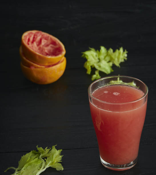 一杯新鲜的柑橘柚子汁。在一张黑色的木桌上。黑色背景。水平的观点。文本。图片下载