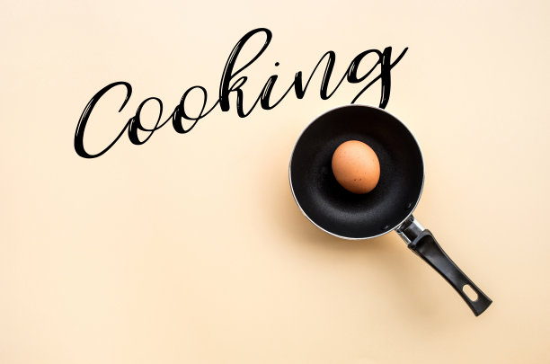 鸡蛋煎在黑色平底锅与烹饪税在deak桌子的背景。食品的概念图片下载