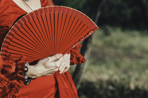 穿着红色衣服的女人，手上拿着红色的扇子和手镯图片下载