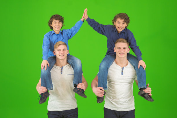 四个可爱的兄弟站在绿色的背景上图片下载