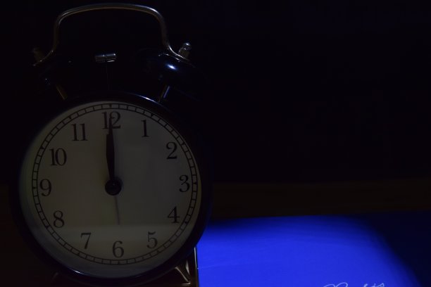 闹钟面在黑色背景上。教育的概念图片下载