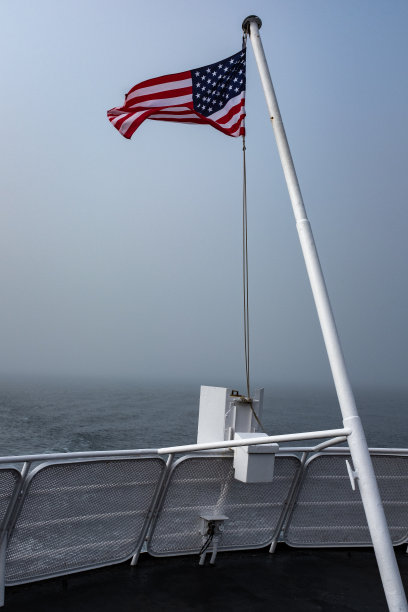 一艘渡往加拿大的渡船上，旗杆顶端的星条旗迎风飘扬图片下载